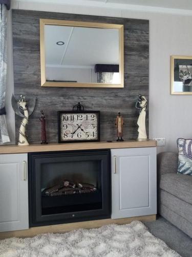 a living room with a fireplace and a mirror at flower pot retreat in Scarborough