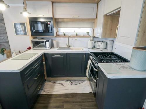 a small kitchen with a sink and a stove at flower pot retreat in Scarborough