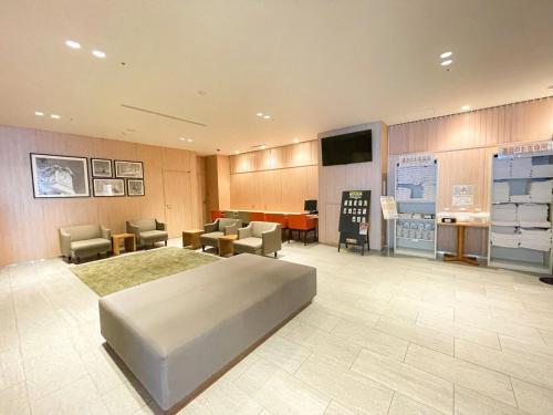 um quarto de hospital com uma cama e cadeiras e uma televisão em Smile Hotel Premium Sapporo Susukino em Sapporo