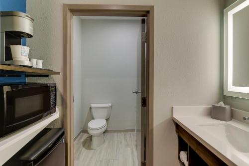 ein Bad mit einem WC und einer Mikrowelle in der Unterkunft Holiday Inn Express Kenner - New Orleans Airport, an IHG Hotel in Kenner