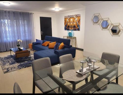 a living room with a blue couch and a table at LV Appartment x Airport Residential Area in Accra
