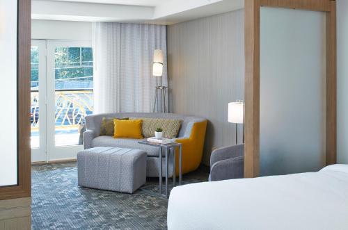 a hotel room with a bed and a chair at Courtyard by Marriott Lake George in Lake George