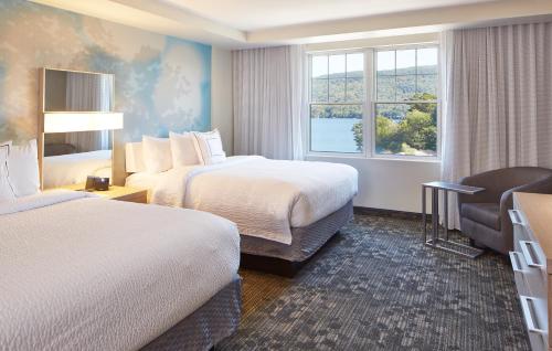 a hotel room with two beds and a window at Courtyard by Marriott Lake George in Lake George