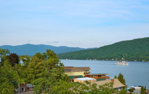 a boat in the water next to a town on a lake at Courtyard by Marriott Lake George in Lake George