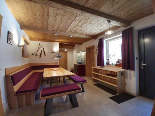 a dining room with a wooden table and purple chairs at Luxury chalet in Tauplitz Styria with sauna and swimming pond in Bad Mitterndorf