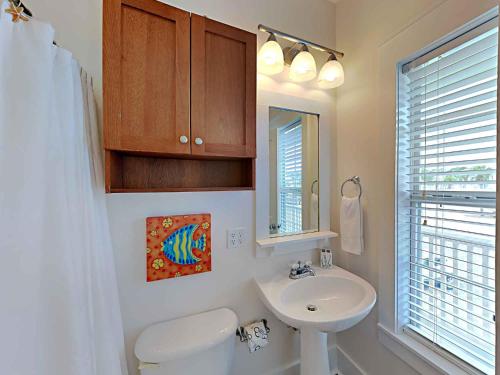 a bathroom with a sink and a toilet and a mirror at Bungalows at Seagrove #132 - Kruks Fanta Sea in Seagrove Beach