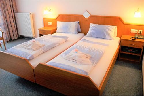 Dos camas en una habitación de hotel con toallas. en Waldhotel Feldbachtal en Neuhaus am Rennweg