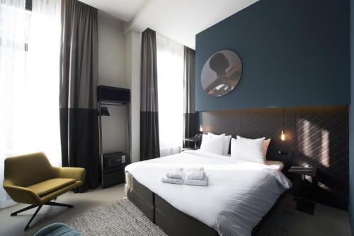 une chambre d'hôtel avec un lit et une chaise dans l'établissement Boutique Hotel Oosteinde, à Amsterdam