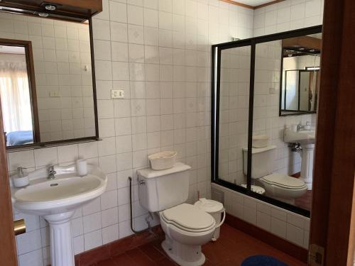 La salle de bains est pourvue de toilettes, d'un lavabo et d'un miroir. dans l'établissement Casa tranquila y central con piscina en Olmué, à Olmué