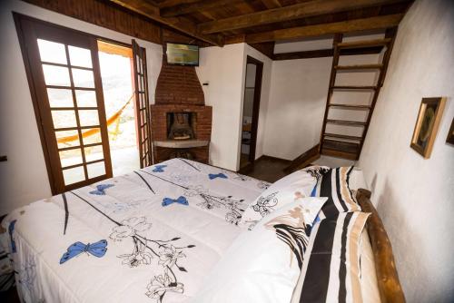 una camera da letto con un letto in una stanza con camino di Pousada do Morro Verde a Carvalhos