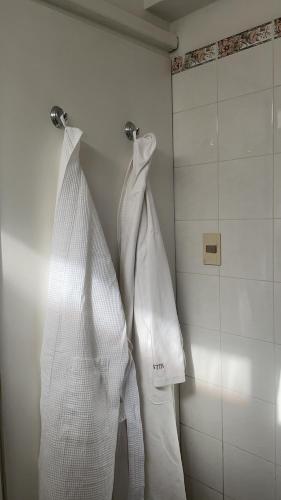 dos toallas blancas colgando en una pared en un baño en Loft en cantegril, en Punta del Este