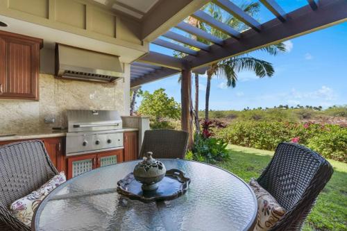 a patio with a table and chairs and a kitchen at Mauna Lani Palm Villas D-2 Corner Unit Historic View in Waikoloa