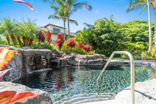 a swimming pool with a waterfall and a swimming pool at Mauna Lani Palm Villas D-2 Corner Unit Historic View in Waikoloa