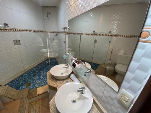 a bathroom with a sink and a toilet and a mirror at Hotel Fazenda Bonanza in Engenheiro Paulo de Frontin