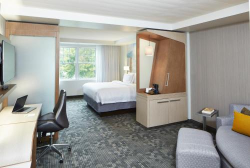 a hotel room with a bed and a desk at Courtyard by Marriott Lake George in Lake George
