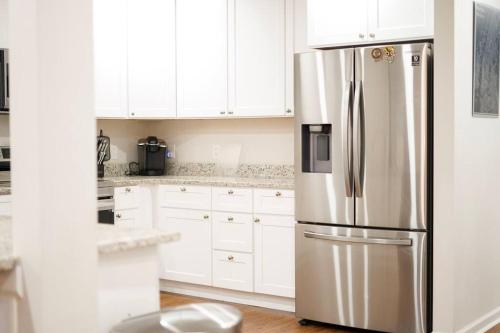 a kitchen with white cabinets and a stainless steel refrigerator at Entire ATL Airport 2 Story House in Atlanta