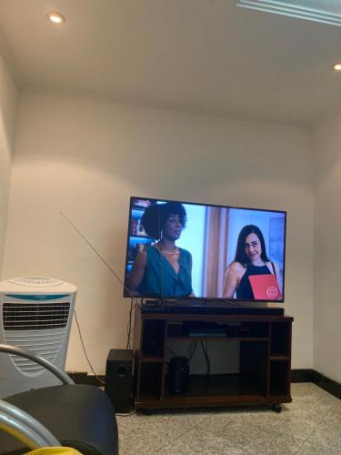 TV de pantalla plana con dos mujeres. en Bahia Flat localização excelente, en Salvador