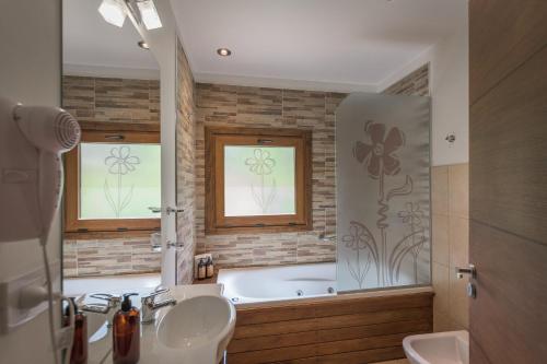 a bathroom with a tub and a sink and a bath tub at Solar Selvana - Casas de montaña in Villa La Angostura