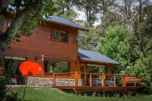 a log cabin with a porch and a deck at Solar Selvana - Casas de montaña in Villa La Angostura