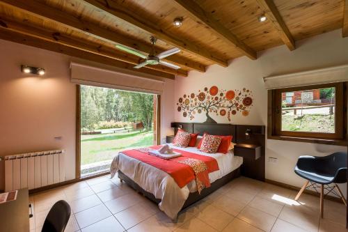 a bedroom with a bed and a large window at Solar Selvana - Casas de montaña in Villa La Angostura