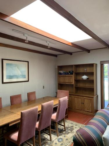 a dining room with a large wooden table and chairs at Casa tranquila y central con piscina en Olmué in Olmué