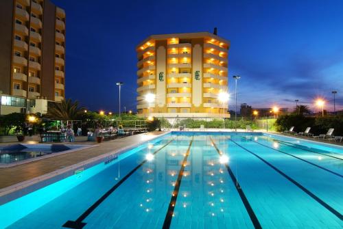 a large swimming pool with a building in the background at Grand Eurhotel in Montesilvano