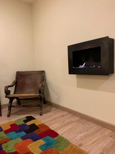 a living room with a chair and a fireplace at HOBU MONTAÑA in La Calera