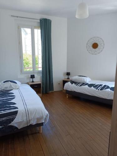 une chambre avec deux lits et une fenêtre dans l'établissement Maison de ville avec extérieur au calme., au Havre