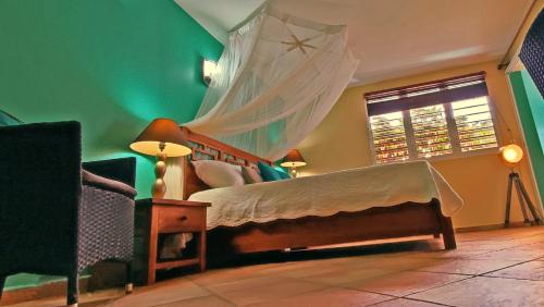 - une chambre avec un lit et une moustiquaire dans l'établissement T1 D'ALICE SAINTE ANNE CENTRE, à Sainte-Anne
