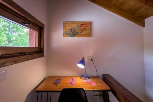a room with a desk with a lamp and a window at Solar Selvana - Casas de montaña in Villa La Angostura