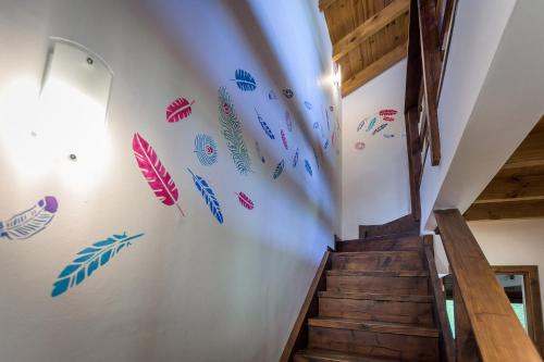 a staircase with colorful wall decals on the wall at Solar Selvana - Casas de montaña in Villa La Angostura