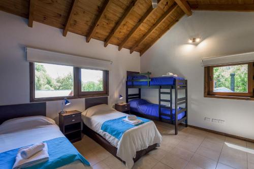 a bedroom with two beds and a blue bunk bed at Solar Selvana - Casas de montaña in Villa La Angostura