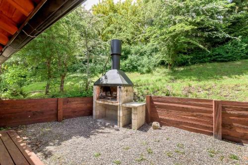 a brick oven sitting next to a wooden fence at Solar Selvana - Casas de montaña in Villa La Angostura