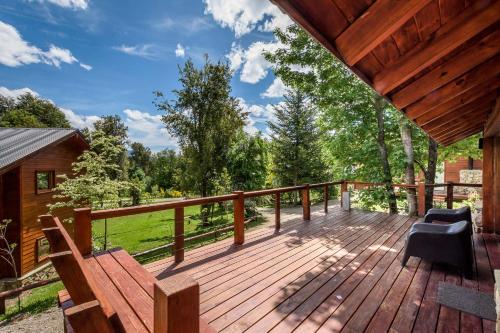 a large wooden deck with a chair on it at Solar Selvana - Casas de montaña in Villa La Angostura