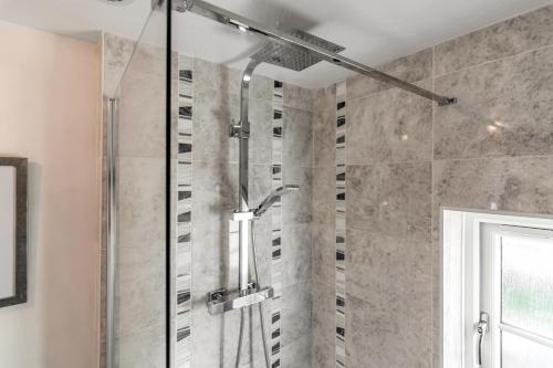 a shower with a glass door in a bathroom at The Old Laundry in Horsham Saint Faith