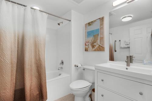 Baño blanco con aseo y lavamanos en Pool Paradise with 75" TV in The Palms of Destin, en Destin