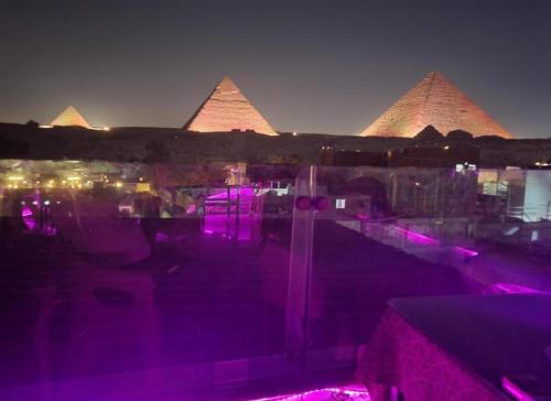 a view of the pyramids at night with purple lights at primo pyramids inn in Cairo