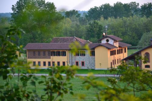 a large building in a field with trees at Agriturismo La Galizia in Cuggiono