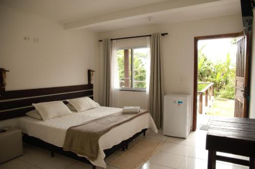 um quarto com uma cama e uma grande janela em Pousada Beira Mar na Ilha do Mel
