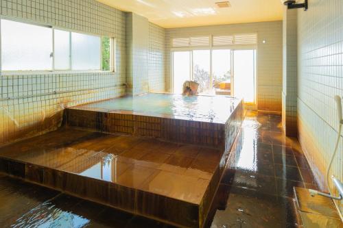 Habitación con bañera de hidromasaje con agua. en Sakurajima Seaside Hotel en Sakurajima