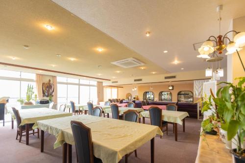 un comedor con mesas, sillas y mesa en Sakurajima Seaside Hotel en Sakurajima
