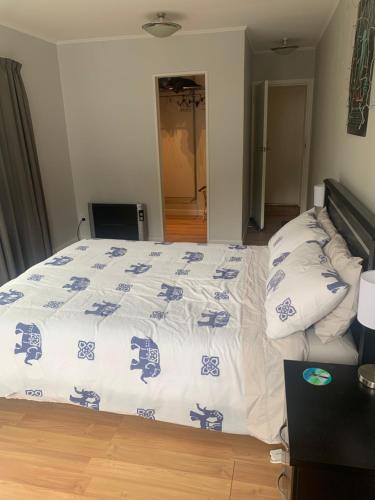 a bedroom with a bed with blue and white sheets at Robert ST Newlands in Wellington