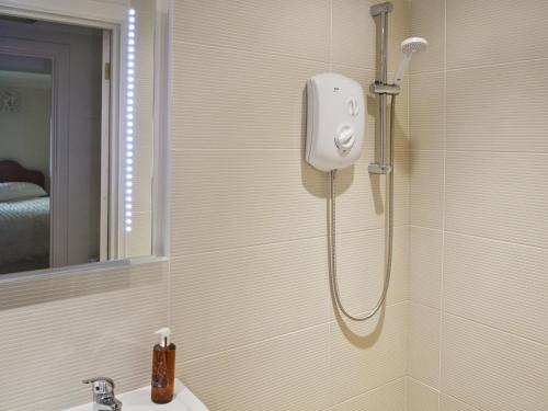 a shower in a bathroom with a sink at The Garden Apartment in Saint Columb Major