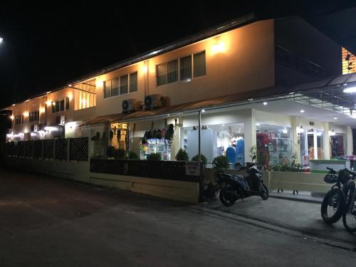 two motorcycles parked in front of a building at night at Nong Nuey Rooms in Ko Samed