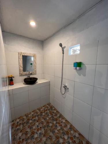 Un baño con ducha con lavabo y espejo. en Bukit Catu Bungalows, en Kintamani