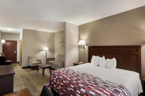 a hotel room with a bed and a chair at Red Roof Inn & Suites Bloomsburg - Mifflinville in Mifflinville
