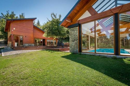 a house with a swimming pool in the yard at Solar Selvana - Casas de montaña in Villa La Angostura