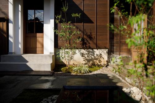 a front door of a house with a plant at Machi no Odoriba in Kanazawa