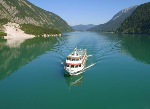 a boat floating on a large body of water at Hotel Garni Berghof in Pertisau