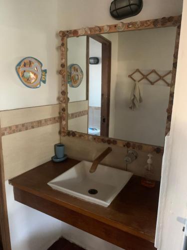 a bathroom with a sink and a mirror at Cabo tortuga bungalows in Monterrico